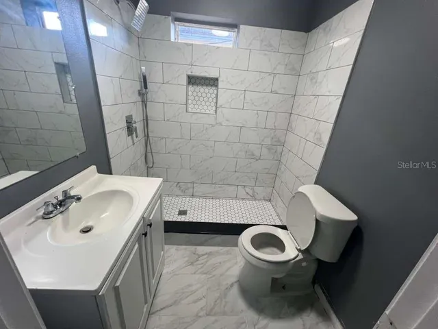 a bathroom with a sink a toilet and a mirror