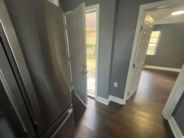 a view of a hallway with wooden floor and glass door