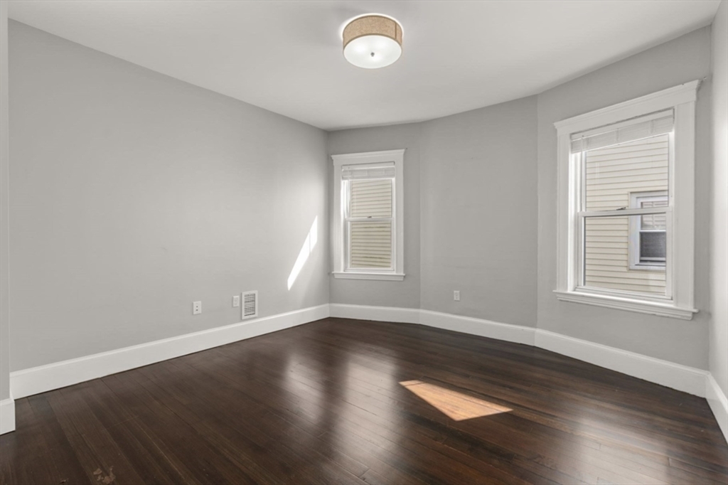 101 Draper Street, Unit 2 Boston, MA 02122 - Photo 8 of 19 a view of an empty room with wooden floor and a window