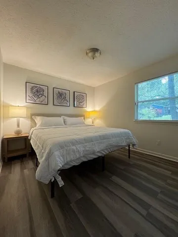 a bedroom with a bed wall painting and a window