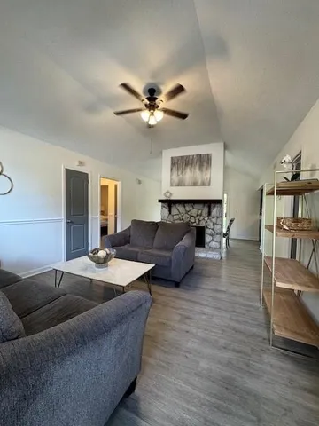 a living room with furniture a fireplace and a flat screen tv