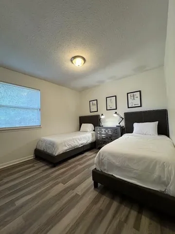 a bedroom with two beds and a night stand