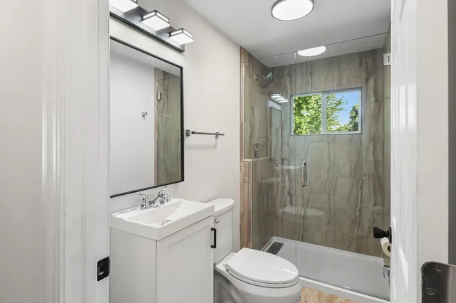 a bathroom with a sink a toilet and shower