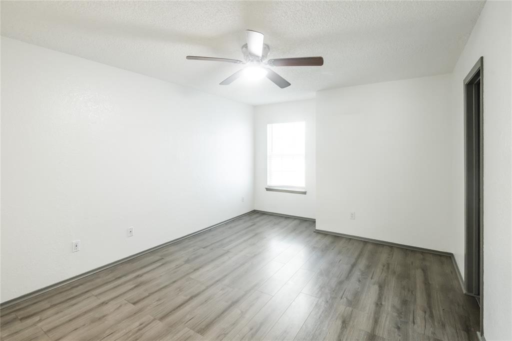 7324 Hyde Court Fort Worth, TX 76112 - Photo 11 of 20 an empty room with wooden floor and windows