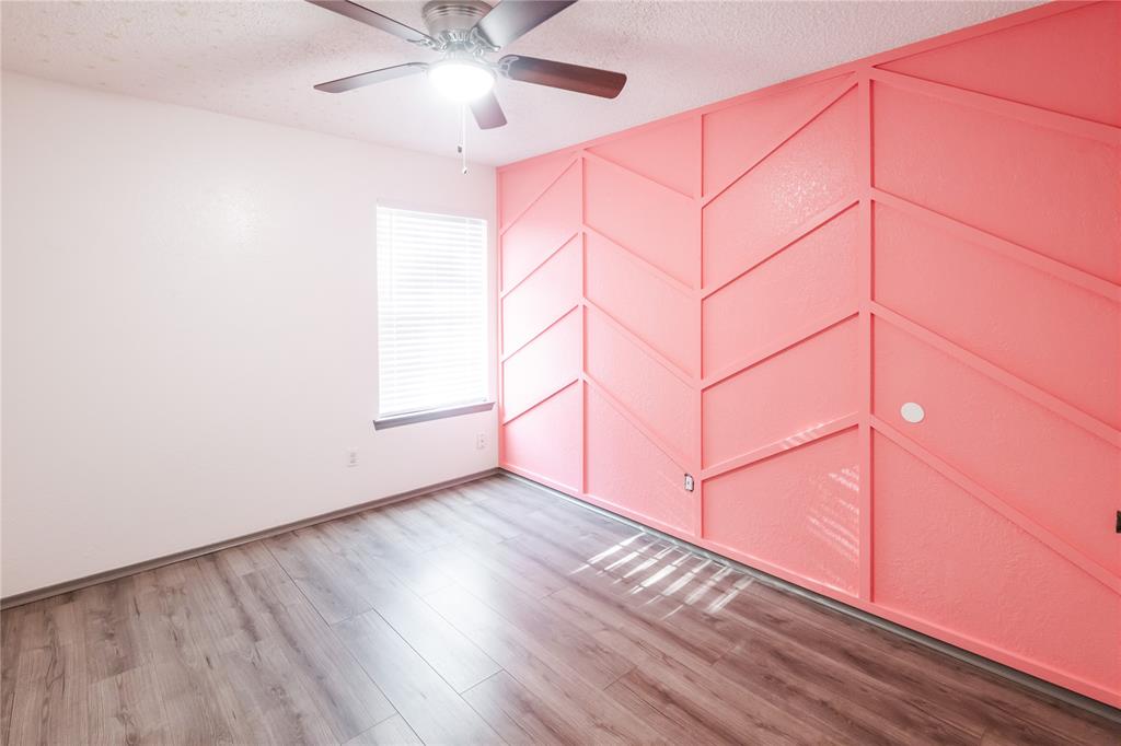 7324 Hyde Court Fort Worth, TX 76112 - Photo 12 of 20 an empty room with wooden floor fan and windows