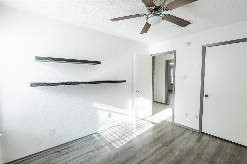 7324 Hyde Court Fort Worth, TX 76112 - Photo 13 of 20 a view of a room with wooden floor and a ceiling fan