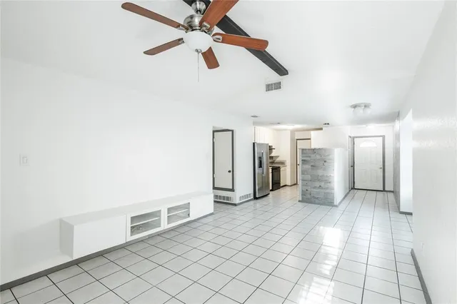 a view of a livingroom with a ceiling fan and staircase
