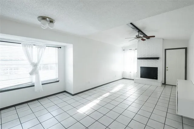 a view of empty room with window and fireplace