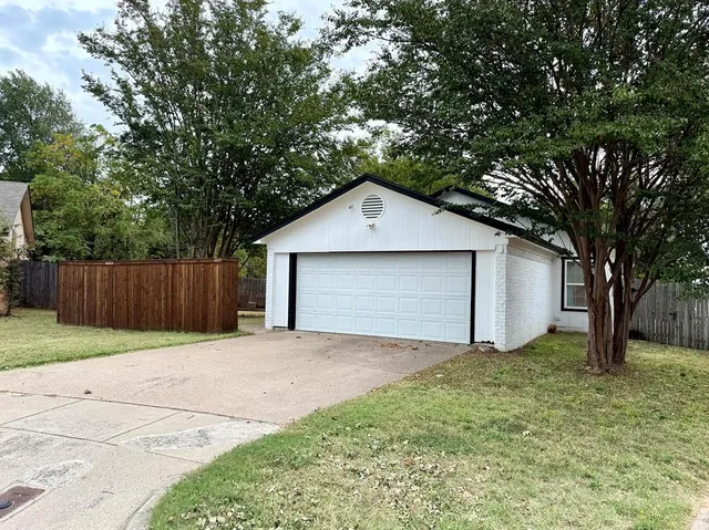 a front view of house with garage and trees
