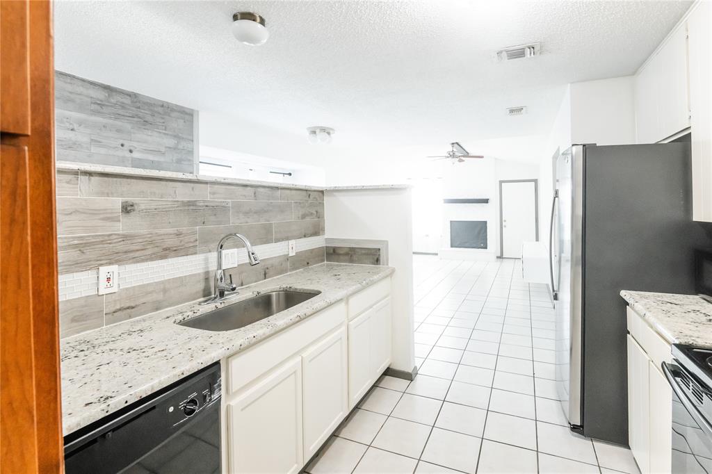 7324 Hyde Court Fort Worth, TX 76112 - Photo 6 of 20 a kitchen with a sink refrigerator and cabinets