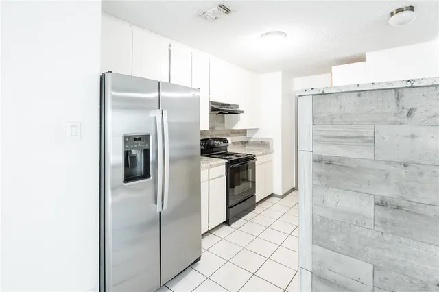 a kitchen with granite countertop a refrigerator and a stove