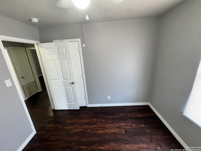 an empty room with wooden floor and a window
