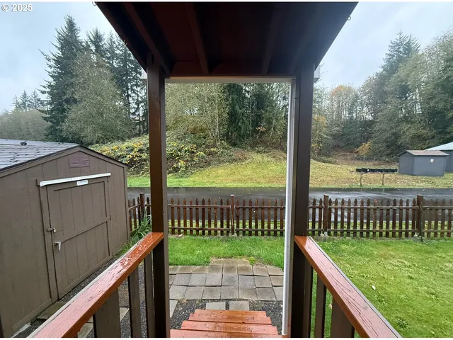 a view of a deck with a floor to ceiling window and a yard