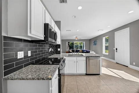 a kitchen with stainless steel appliances granite countertop a sink stove and cabinets