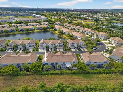 an aerial view of residential houses with outdoor space and lake view