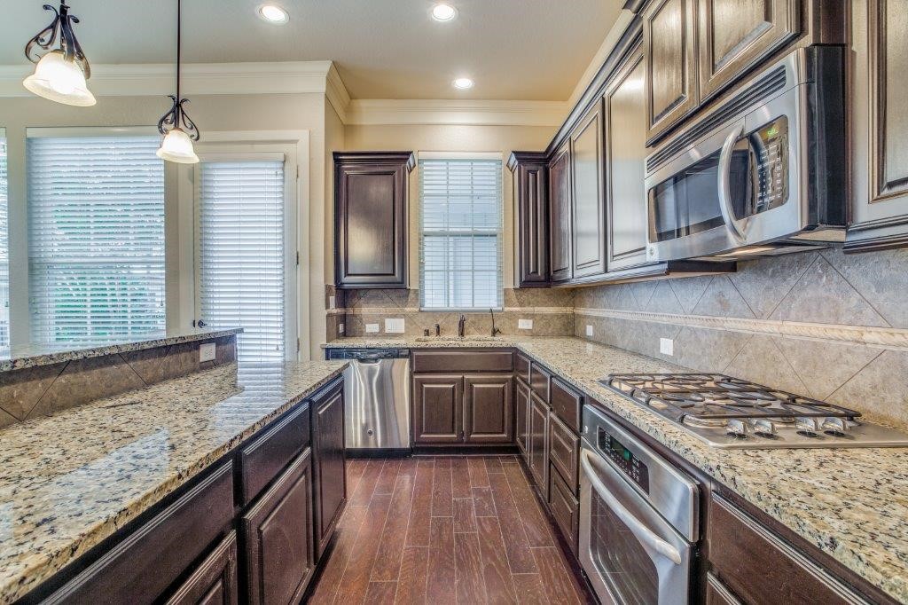 46 East Rafters Row The Woodlands, TX 77380 - Photo 9 of 25 Granite countertops, gas cooking, stainless appliances, and generous prep space make this kitchen both beautiful and functional.