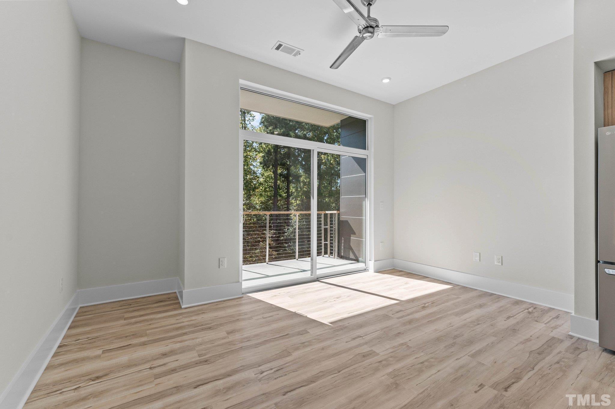 2441 Campus Shore Drive, Unit 309 Raleigh, NC 27606 - Photo 11 of 49 a view of an empty room with wooden floor and a window