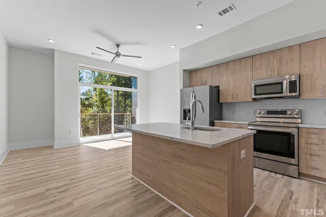a kitchen with kitchen island granite countertop a sink appliances and cabinets