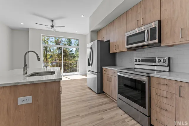 a kitchen with stainless steel appliances a stove microwave and sink