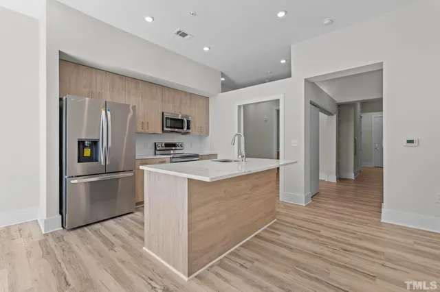 a kitchen with stainless steel appliances granite countertop a refrigerator and a stove top oven