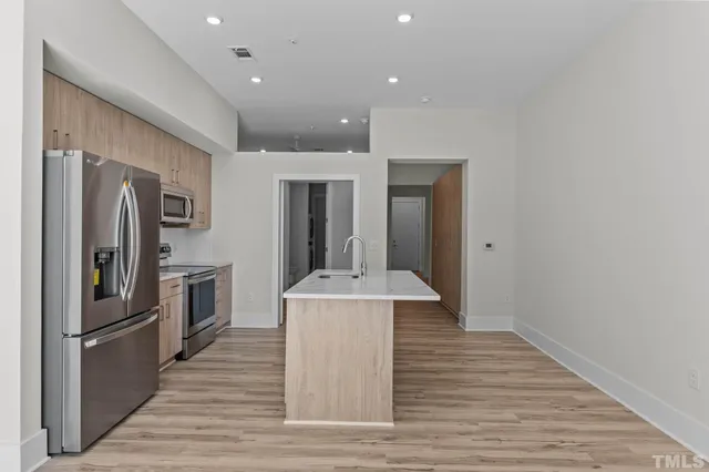 a kitchen with stainless steel appliances a refrigerator and a stove