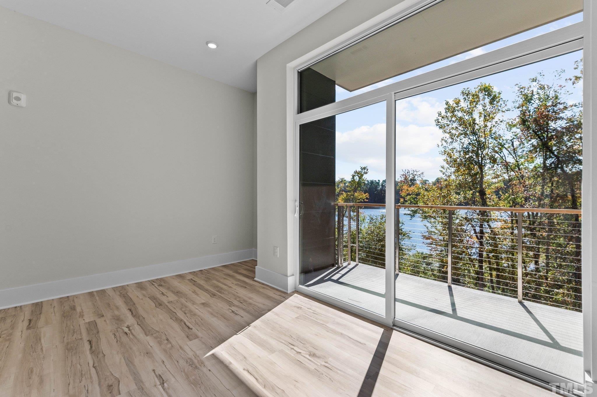 2441 Campus Shore Drive, Unit 309 Raleigh, NC 27606 - Photo 10 of 49 a view of empty room with wooden floor and floor to ceiling window