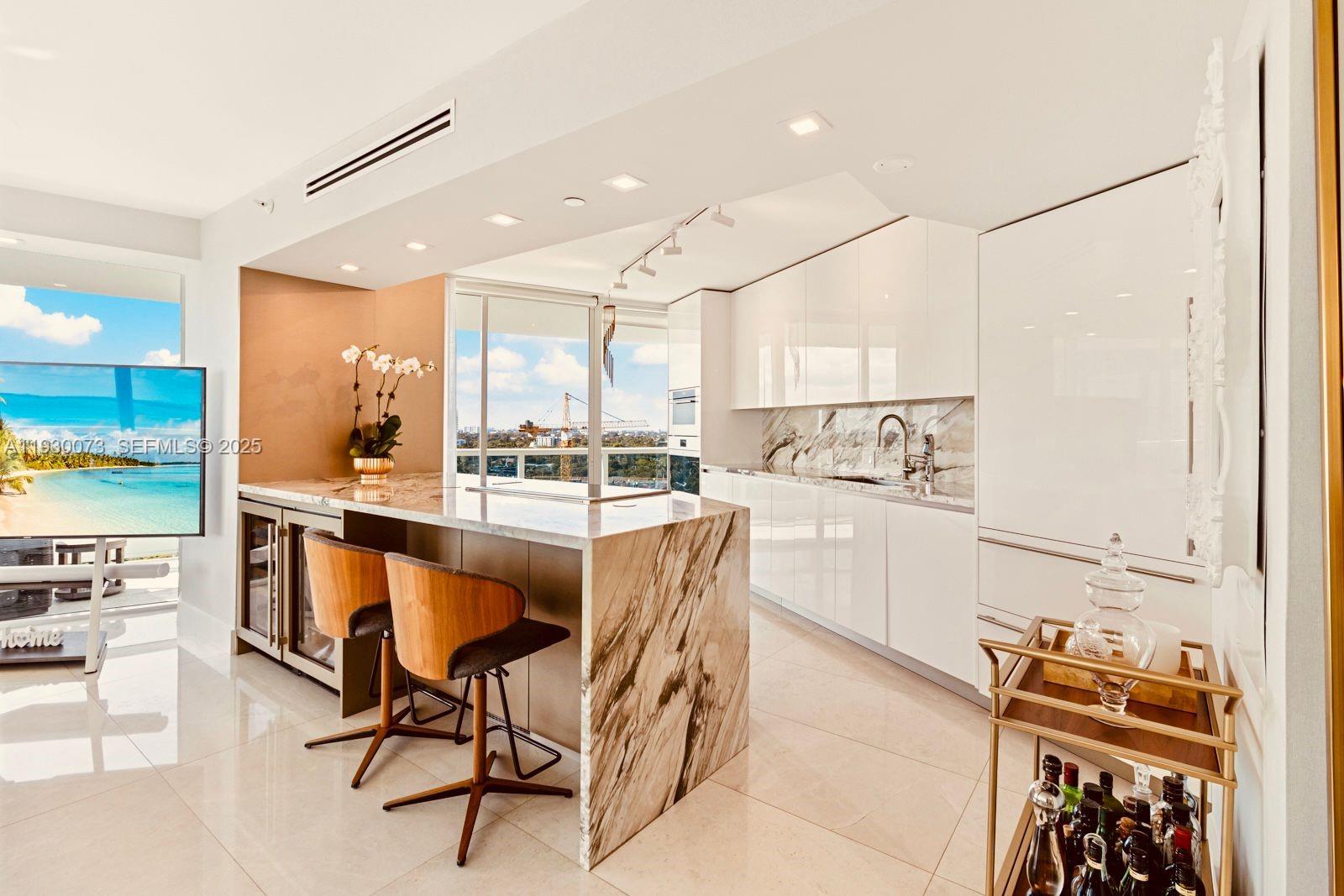 2127 Brickell Avenue, Unit 1505 Miami, FL 33129 - Photo 13 of 37 a kitchen with stainless steel appliances kitchen island granite countertop a refrigerator and a stove top oven