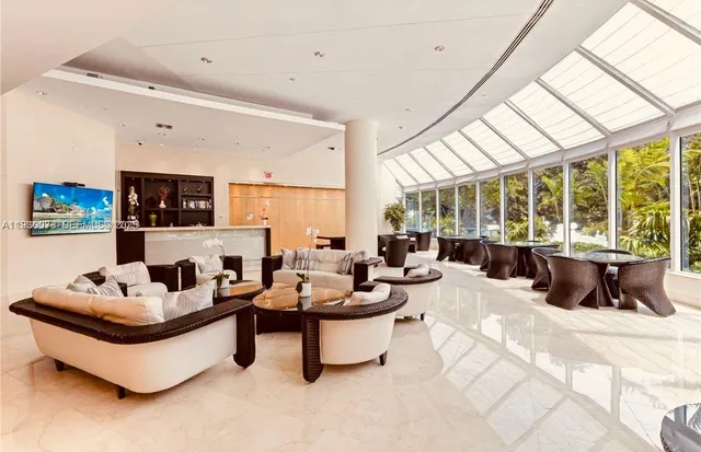 a living room with furniture and floor to ceiling windows