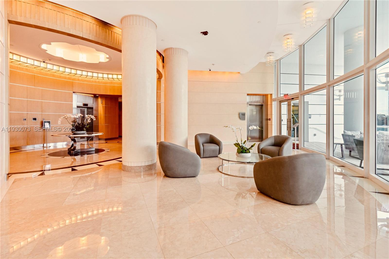 2127 Brickell Avenue, Unit 1505 Miami, FL 33129 - Photo 28 of 37 a living room with furniture a large window and chandelier