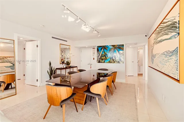 a view of a dining room with furniture one side kitchen view and wooden floor