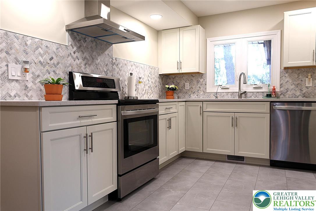 8297 Mertztown Road Lower Macungie Township, PA 18011 - Photo 6 of 22 a kitchen with cabinets appliances a sink and a window