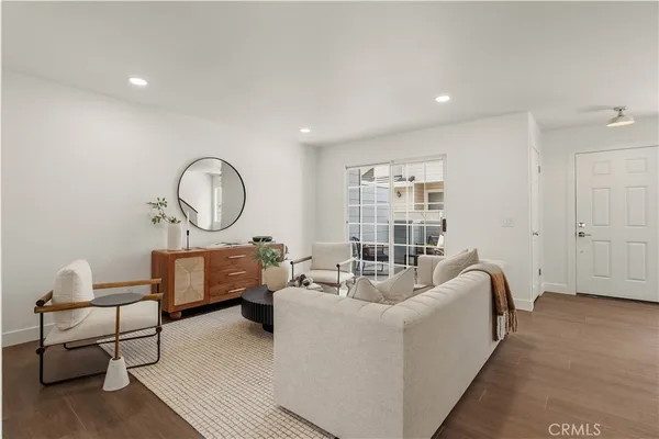 a living room with furniture a rug a lamp and a window