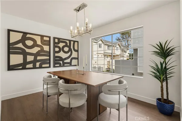 a dining room with furniture a chandelier and wooden floor