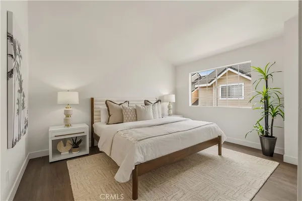 a bedroom with a bed a mirror and a potted plant