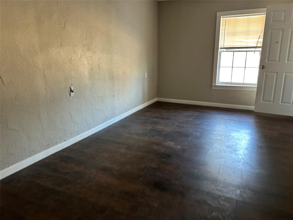 103 East Cayuga Drive Athens, TX 75751 - Photo 4 of 11 an empty room with wooden floor and windows