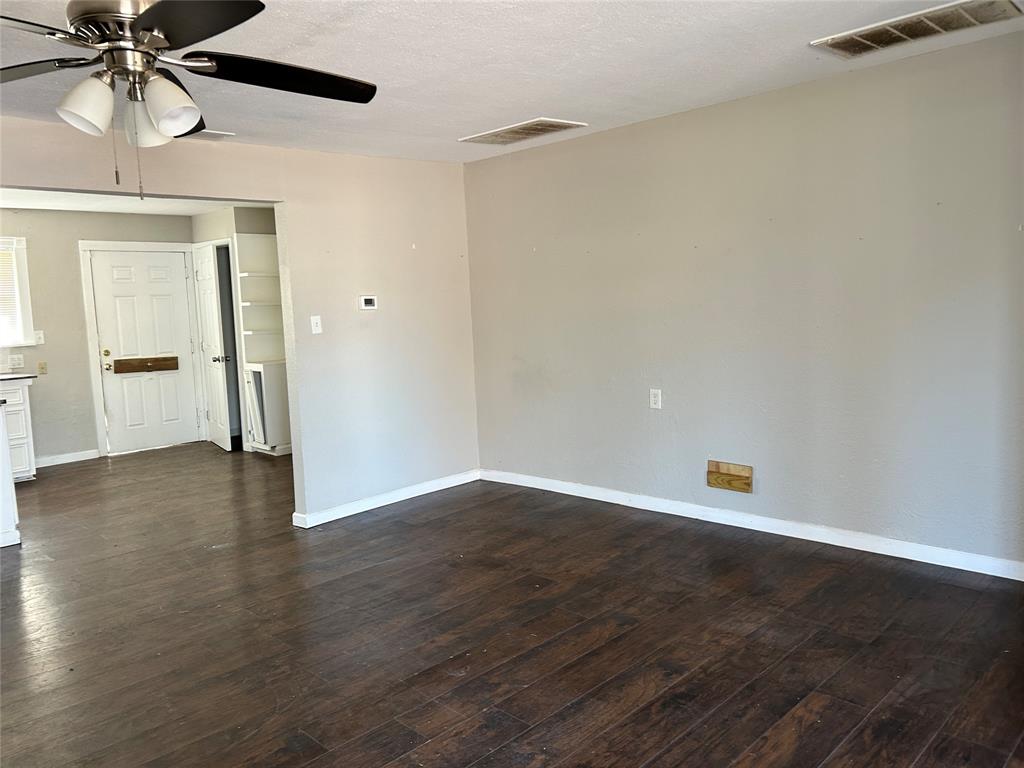 103 East Cayuga Drive Athens, TX 75751 - Photo 7 of 11 an empty room with wooden floor chandelier fan and windows