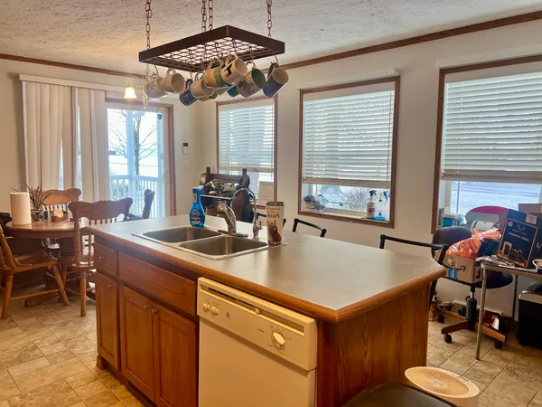 a kitchen with a sink a counter and chairs