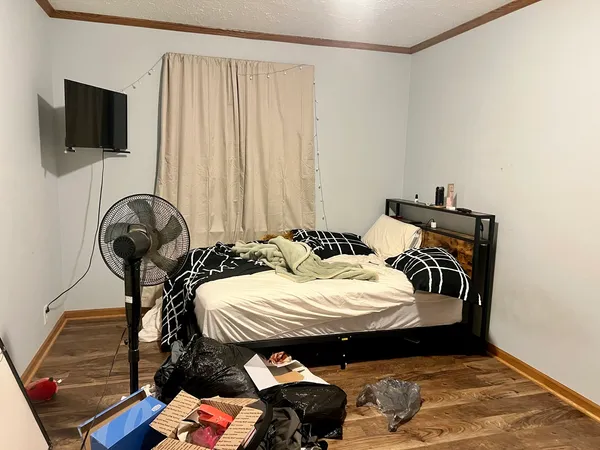 a bedroom with a bed and a flat screen tv