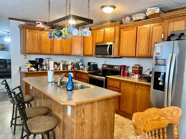 a kitchen with a refrigerator a stove a sink a dining table and chairs