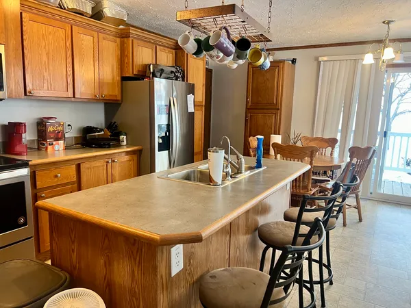 a kitchen with stainless steel appliances kitchen island granite countertop a table chairs in it and wooden floors