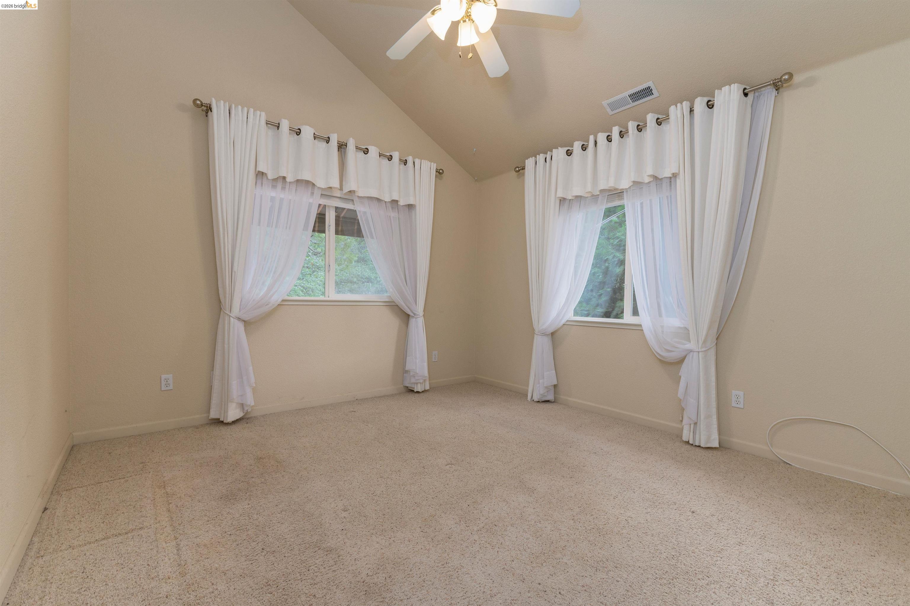 22401 Ridge Road Twain Harte, CA 95383 - Photo 25 of 56 Spacious room featuring vaulted ceilings, two large windows, neutral wall tones, and plush carpeting