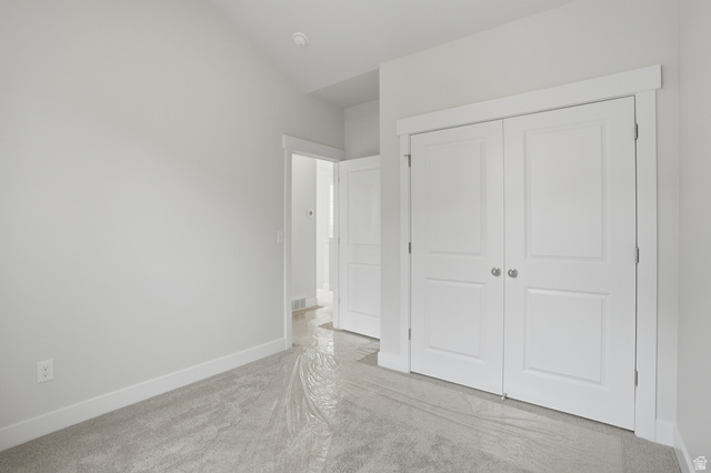 7338 South Seven Tree Lane, Unit 75 Midvale, UT 84047 - Photo 20 of 30 Unfurnished bedroom featuring light carpet and a closet