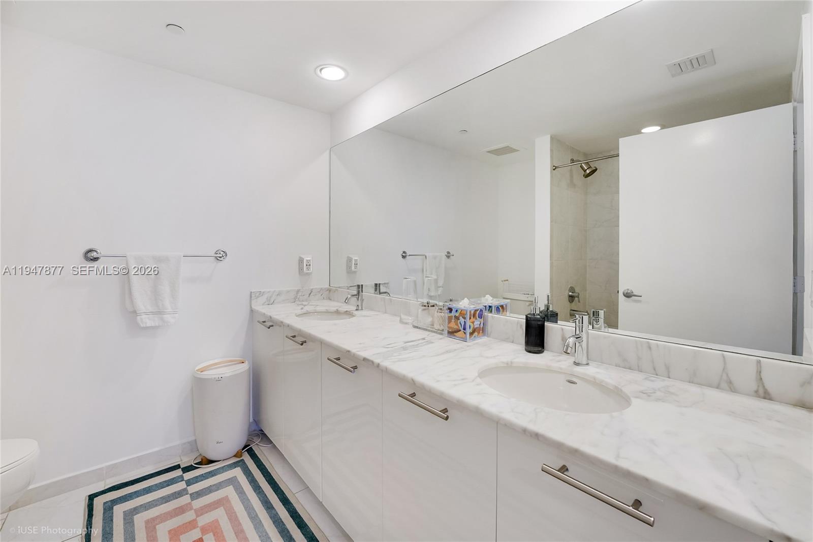 951 Brickell Avenue, Unit 1110 Miami, FL 33131 - Photo 19 of 28 a bathroom with a double vanity sink and mirror