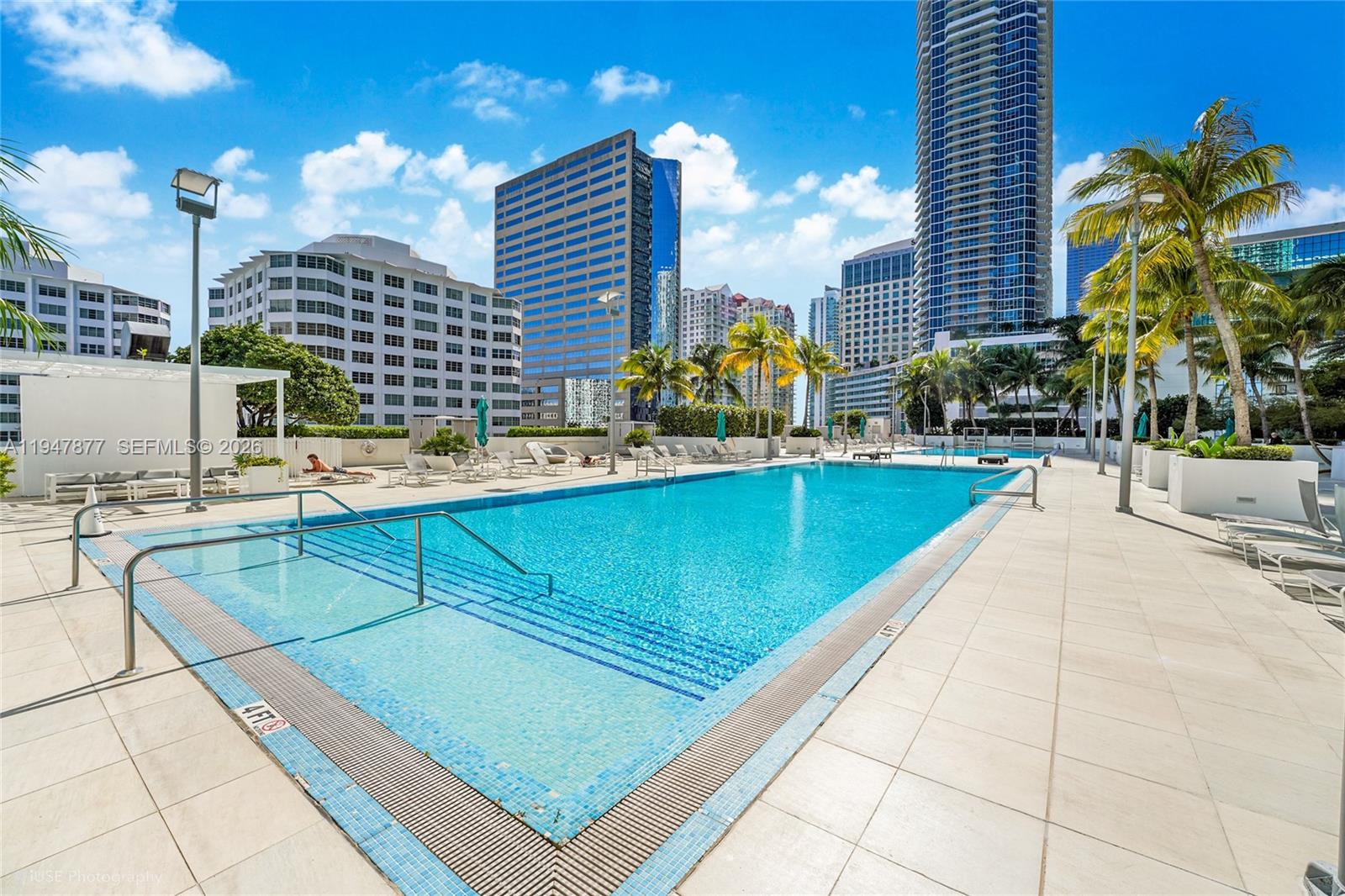 951 Brickell Avenue, Unit 1110 Miami, FL 33131 - Photo 26 of 28 a view of a swimming pool with a lounge chairs