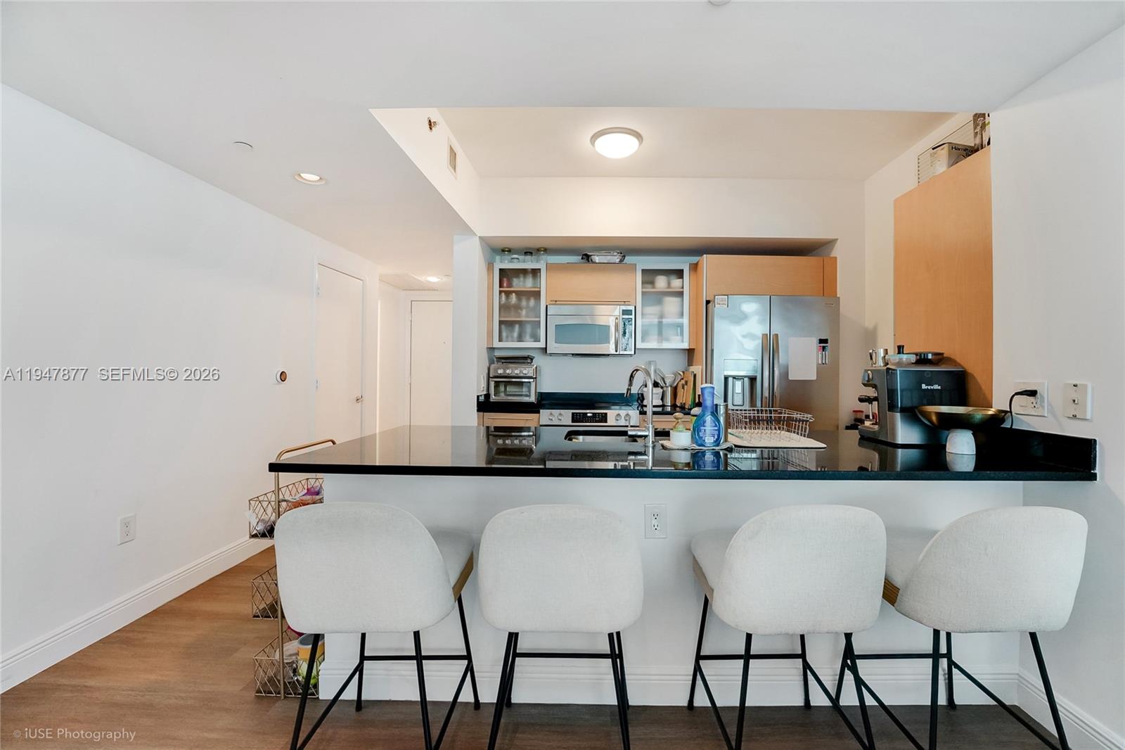 951 Brickell Avenue, Unit 1110 Miami, FL 33131 - Photo 3 of 28 a kitchen with stainless steel appliances a dining table chairs and a large window
