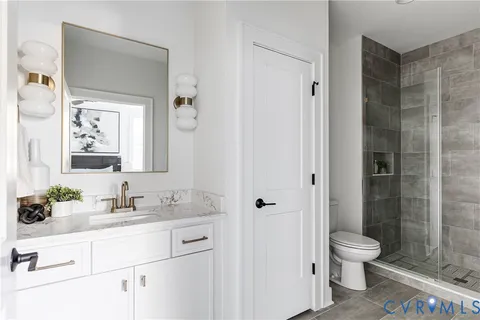 a bathroom with a granite countertop sink toilet a mirror and shower