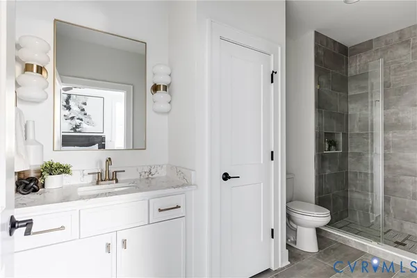 a bathroom with a granite countertop sink toilet a mirror and shower