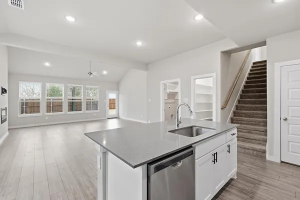 a kitchen with center island wooden floor and stainless steel appliances