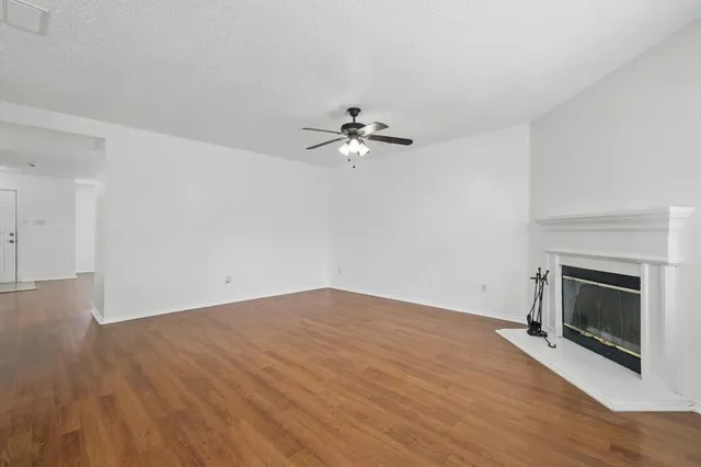 an empty room with fan and fireplace