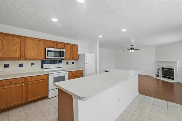 a kitchen that has a lot of cabinets and wooden floor